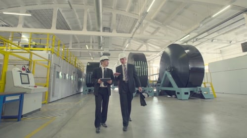 Men Discussing Business On Factory