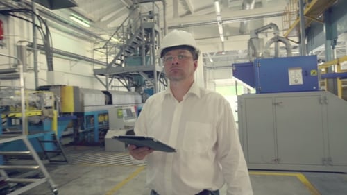 Ingenieur geht durch die Fabrik