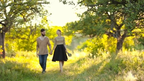 Romantic Couple Walking Hand-in-Hand at Golden Hour