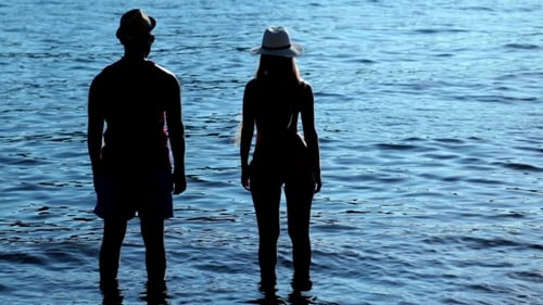 Silhouette Couple Holding Hands At Sunset On Beach
