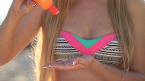 Young Pretty Woman Applying Sunscreen