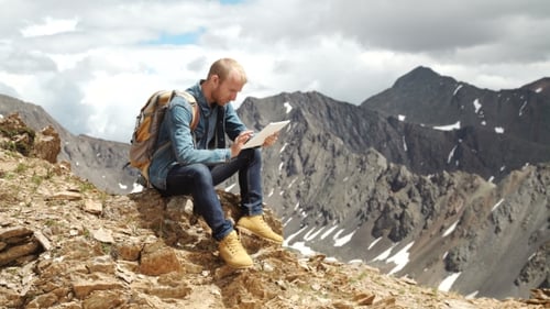 Man's Hands Touching Screen Of Digital Tablet On The Background Of Mountains
