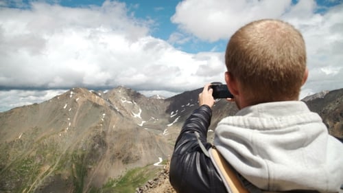 Tourist Takes Photos With Smart Phone On Peak Of Rock