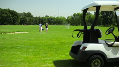 The Couple Turn Back To The Cart At The Course