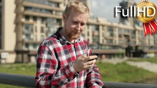 Man Writes a Message on a Smartphone