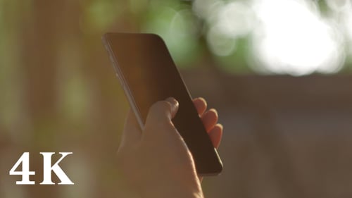 Hand Holding a Mobile Phone Outdoors