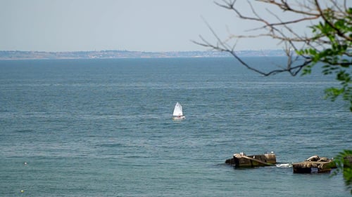 Die im Meer schwimmende Yacht. Am fernen Ufer kann man die Stadt sehen