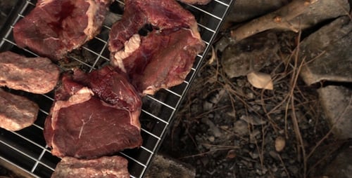Raw Beef Steaks and Burgers on Grill