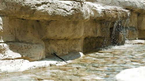 Small Waterfall Flowing Over Rocks into Pool