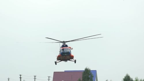 Russland, Nowosibirsk, 31. Juli 2016: Orangener Hubschrauber MI-8 über der grünen Wiese und den Bäumen.