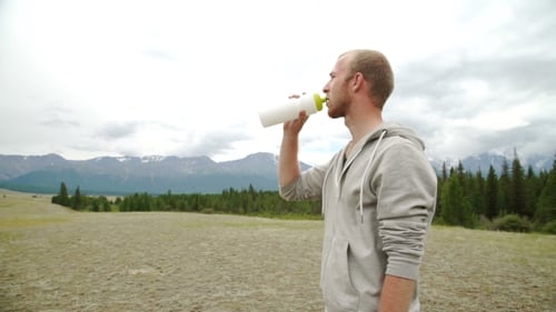 Hiker Drinks Clear Water On Top Of The Mountains