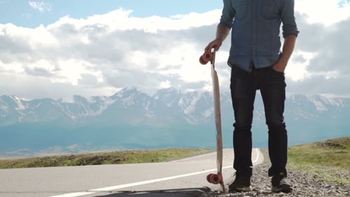 Teenager With Longboard on Mountain Road