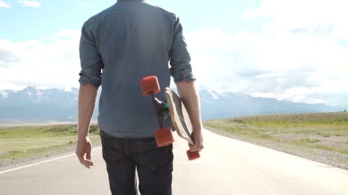 Skateboarder on Rural Road with Mountain View