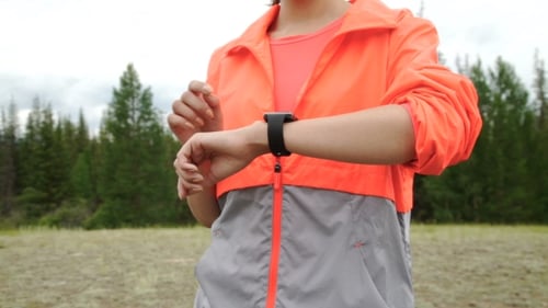 Runner Using Smartwatch Fitness Tracker And Heart Rate Monitor Watch Jogging On Trail In Forest