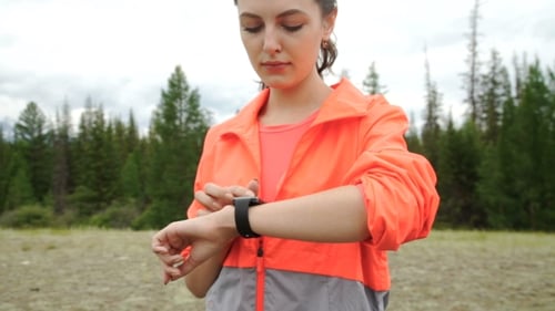 Läufer mit Smartwatch Fitness-Tracker und Herzfrequenzmesser beobachten Joggen auf Trail im Wald