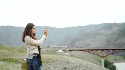 Young Woman Photographs Scenic Mountain Landscape