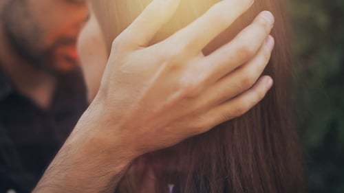 Loving Man Holding Woman's Head in Golden Sunlight