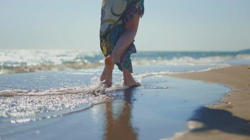 Barefoot Woman Walking on Sunny Beach Shoreline