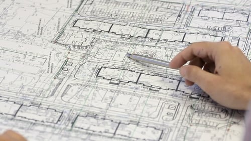 Männlicher Architekt überprüft Blaupausen Hausbauplanung.
