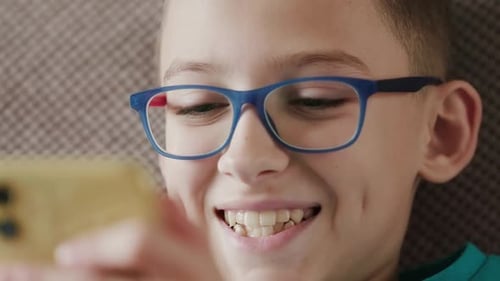 Smiling Boy Using Smartphone in Close Up