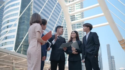 Enthusiastic Team Celebration in Front of Modern Skyscrapers