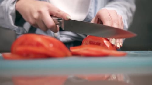 Front View of Woman's Hands Slicing Fresh Red Tomatos on Cutting Board in Slow Motion