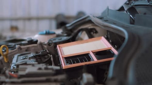 Automechaniker in der Servicestation wechselt den Luftfilter im Auto