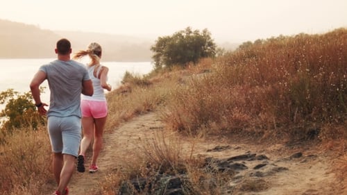Man and Woman Jogging Along a Mountain Path