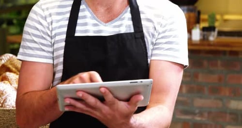 Male waiter using digital tablet