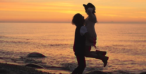 Romantic Couple Embraces on the Beach at Sunset