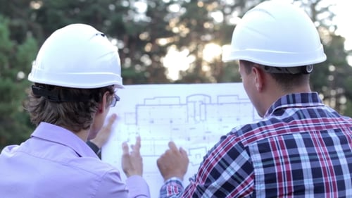 Engineers Reviewing Blueprints on Construction Site