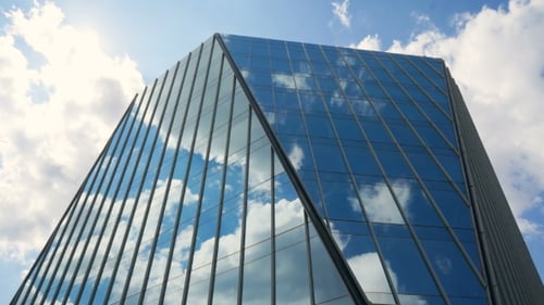 Office Building Skyscraper in the Windows of which reflected the passing clouds