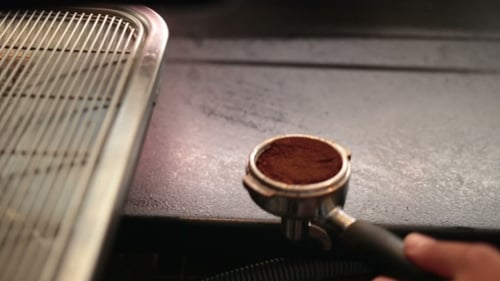 Barista Compressing Coffee in a Portafilter Close Up