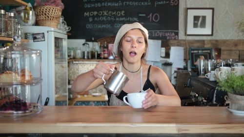 Woman Making Coffee at Cafe Counter