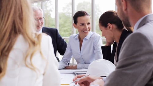 Architects With Blueprint Meeting At Office 35