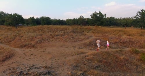 Active Couple Runs Together on a Nature Trail