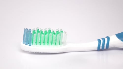 Squeezing Pink Toothpaste on a Toothbrush, Close Up