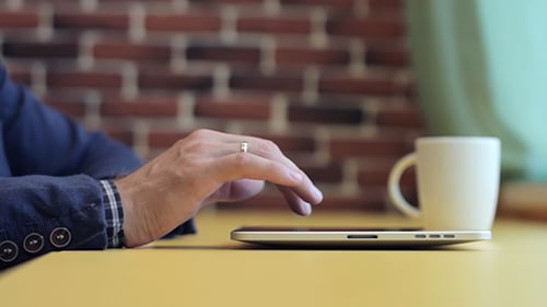 Man Working on Tablet with Coffee Cup