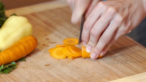 Slicing Carrot on Cutting Board Close Up