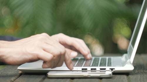 Hands Typing on Laptop Computer Outdoors