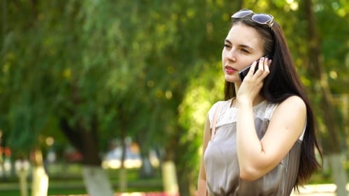 Woman Talking on Phone in Green Urban Park