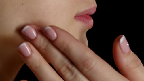 Maskenbildner tragen Creme auf das Gesicht des Models auf. Schwarz.