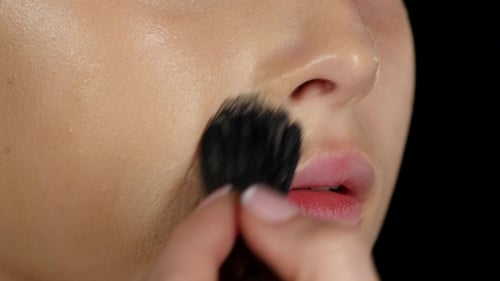 Makeup Artist Applies Concealer On The Model's Face. Black.