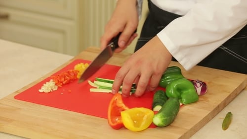 Chef Dicing Fresh Vegetables on Cutting Board