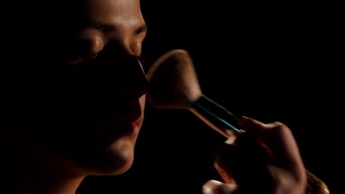 Woman Applying Makeup with Brush Close Up
