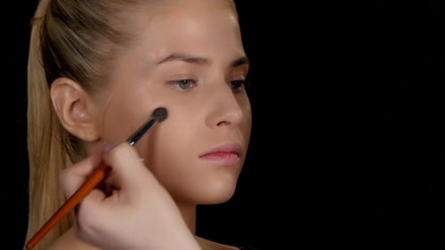 Applying Highlighter. Makeup. Black.