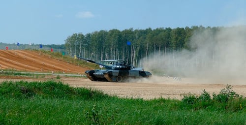 Powerful Military Tank Moving Across Dusty Terrain