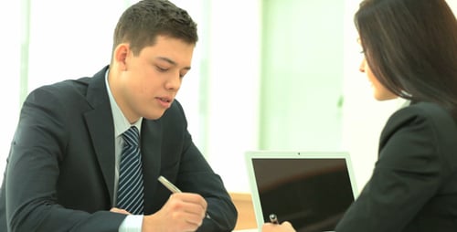 Young Professionals in Corporate Meeting Taking Notes