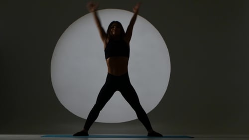 Woman Doing Yoga Stretches in Fitness Studio