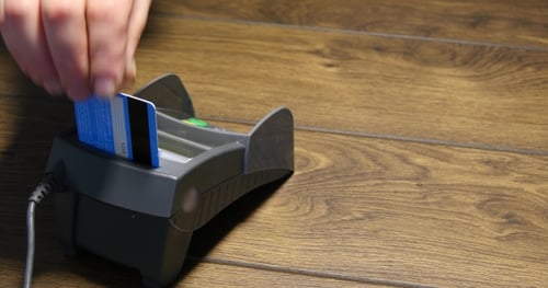 Person Using Credit Card Processing Terminal